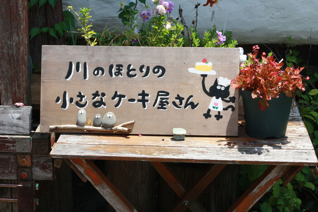 看板「川のほとりの小さなケーキ屋さん」
